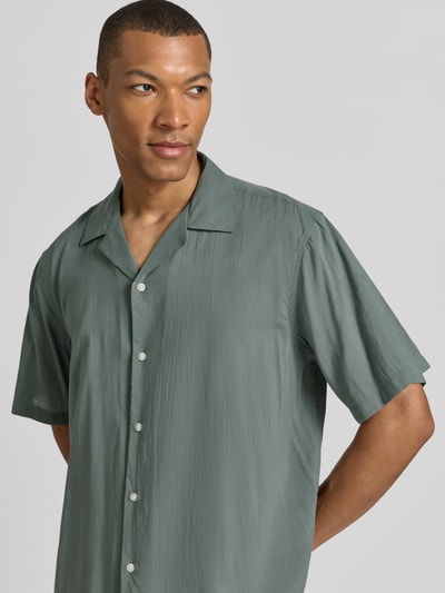 Męski model nosi Relaxed Fit Freizeithemd aus Baumwoll-Mix Modell 'RELAXAIR' od SELECTED HOMME, jednobarwny, krótki rękaw, bawełniany miks, krój relaxed fit, kołnierz bowlingowy, przód z guzikami, całkowite ujęcie przód.
