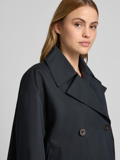 Kobiece model prezentuje Trenchjacke mit Reverskragen Modell 'HEATHER' od G-LAB, kolor ciemny, prosty krój, zbliżenie na górę ciała