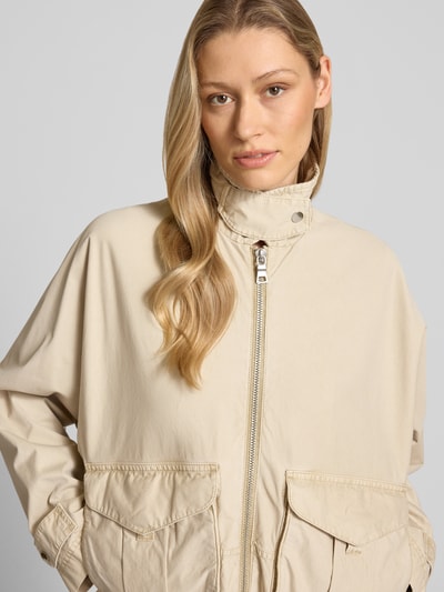 Mädchen trägt Jacke mit Zweiwege-Reißverschluss von Blonde No. 8, beżowy kolor, czysta bawełna, luźny krój, z kieszeniami, zbliżenie górnej części ciała.