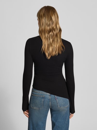Vrouwenmodel draagt zwart shirt met lange mouwen van Topshop, Model 'RIA', Mix van viscose en elastaan, slim fit, riblook, asymmetrische look, ronde hals, ruglengte maat S 55 cm, geheelbeeld achteraan.