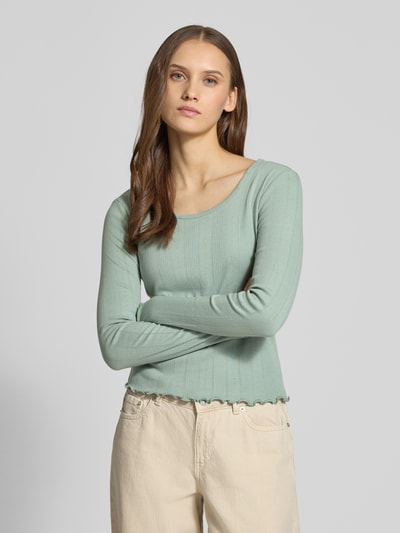 Frauenmodel trägt Slim Fit Langarmshirt aus Bio-Baumwoll-Mix Modell 'TENNA LIFE' von ONLY in Optik: unifarben, Feinstrick Lochstrickmuster, Frill-Abschlüsse, U-Boot-Ausschnitt, Nahaufnahme Oberkörper.