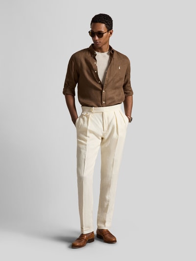 Mannenmodel draagt Slim Fit vrijetijdsoverhemd uit puur linnen van Polo Ralph Lauren, look: effen kleuren, langemouwen, logodetail, button-downkraag, enkele knoopsluiting, sportmanchet, rompzoom licht afgerond, materiaalverwerking: gevlamd garen, materiaal: linnen. Volledige lichaamsopname vooraanzicht.