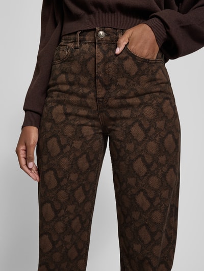 Frauenmodel trägt Straight Fit Jeans mit 5-Pocket-Design von ROTATE, reine Baumwolle, braunes Schlangen-Muster, Nahaufnahme Oberkörper.