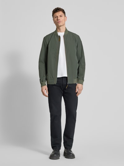 Männermodel trägt Bomberjacke mit Reißverschluss und Eingrifftaschen von PME Legend in Olivgrün mit Stehkragen, Regular Fit, Ganzkörperansicht von vorne. Material-Mix mit Stretch-Anteil, klassische Länge, sichtbar strukturierte Oberfläche.