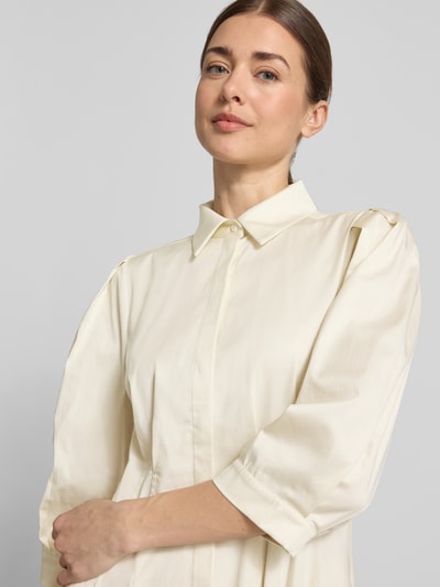 Frauenmodel trägt Cocktailkleid mit verdeckter Knopfleiste und 3/4-Arm von Christian Berg Cocktail aus Satin im taillierten Schnitt, Nahaufnahme Oberkörper.