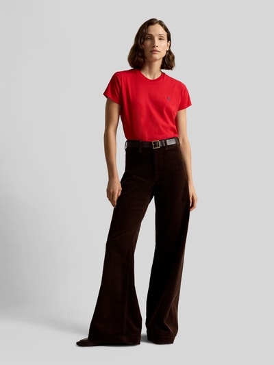 Frauenmodel trägt Regular Fit T-Shirt aus reiner Baumwolle von Polo Ralph Lauren in Rot, kombiniert mit dunkelbrauner Hose, Ganzkörperansicht von vorne. Damen T-Shirt von Polo Ralph Lauren.