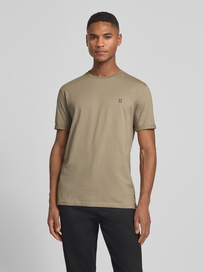 Männermodel trägt T-Shirt mit Logo-Stitching Modell 'Norregaard' von Les Deux in Beige, reine Baumwolle, gerader Schnitt, Ganzkörperansicht von vorne.