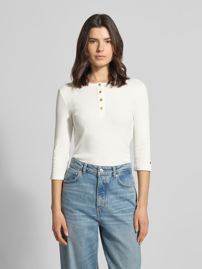 Frauenmodel trägt Slim Fit T-Shirt aus reiner Baumwolle von Tommy Hilfiger in Optik: unifarben, Feinripp, Logo-Detail, 3/4-Arm, Ganzkörperansicht von vorne.
