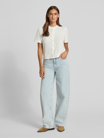 Frauenmodel trägt Strickshirt aus Viskose-Mix mit Knopfleiste von Christian Berg Woman in Weiß, Regular-Fit, Rundhalsausschnitt, Rückenlänge bei Größe S 52 cm, Ganzkörperansicht von vorne.