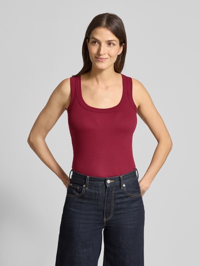 Modelka kobieca nosi Tanktop mit geripptem Rundhalsausschnitt von Marc Cain, krój slim fit, kolor bordowy, tekstura prążkowana, długość tyłu w rozmiarze 36: 45 cm, widok całej sylwetki z przodu.