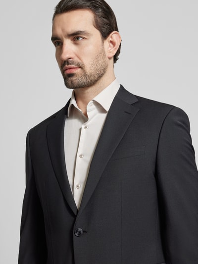 Męski model nosi Slim Fit 2-Knopf-Sakko mit Pattentaschen von HECHTER PARIS, mieszanka żywej wełny z dodatkiem streczu, kołnierz z połami, kieszenie z patką, czarny kolor, rozmiar 50: długość tyłu 73 cm, szerokość ramion 46 cm, długość rękawów 65 cm, krój slim fit, zbliżenie na górną część ciała.