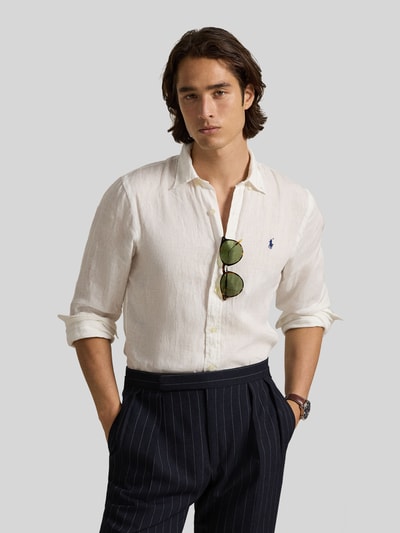 Mannelijk model draagt 'Slim Fit Freizeithemd aus reinem Leinen' van Polo Ralph Lauren in effen wit linnen, met logo-stitching, slim fit, button-down kraag, volledige knoopsluiting, sportmanchet en afgeronde zoom. Ganzkörperansicht van voren.