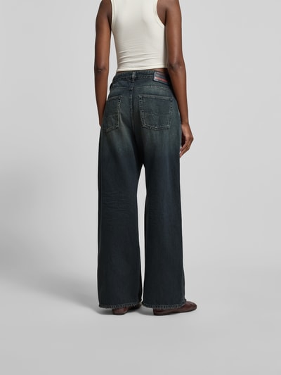 Frauenmodel trägt Wide Fit Jeans mit Logo-Patch von Diesel aus Reiner Baumwolle im 5-Pocket-Design, dunkelblauer Denim, Ganzkörperansicht Rückansicht.