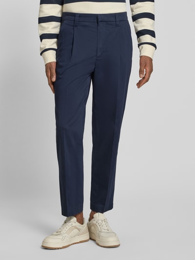 Männermodel trägt Regular Fit Chino aus Baumwoll-Mix Modell 'TAAMIR PLEATED' von Armedangels, unifarben, Mid Waist, Nahaufnahme Unterkörper.
