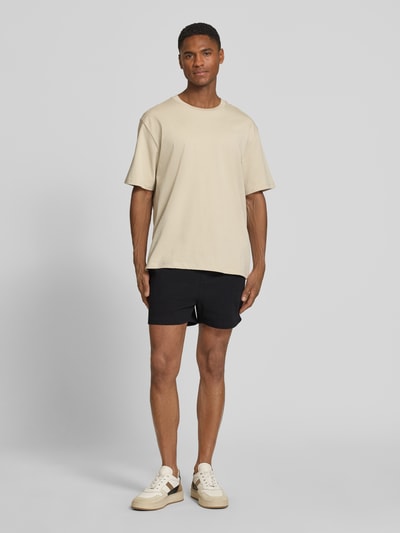Männermodel trägt Regular Fit Shorts aus Baumwoll-Mix Modell 'FILIP' von Strellson, unifarben, elastischer Bund, Jacquard-Struktur, Ganzkörperansicht von vorne.