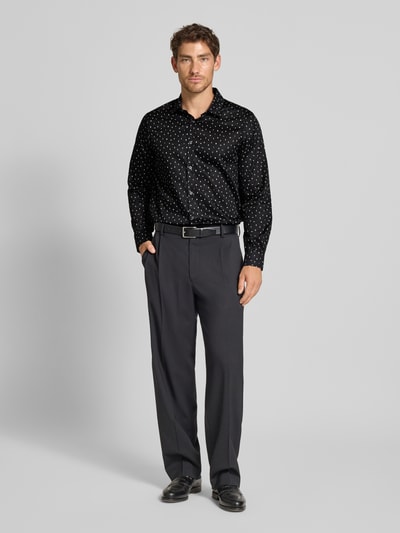 Männermodel trägt Freizeithemd mit Knopfleiste Modell 'CAMICIA' von ARMANI EXCHANGE, schwarze Baumwolle mit weißen Punkten, regular fit, ganzkörperansicht von vorne.