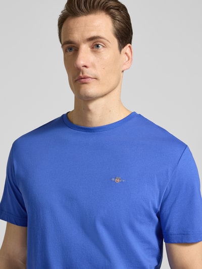 Männermodel trägt Regular Fit T-Shirt mit Logo-Stitching van Gant in blauw, ronde hals, katoen, pure textuur, Nahaufnahme Oberkörper.