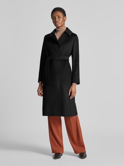 Vrouwenmodel draagt zwarte lange jas van scheerwol model 'BCOLLAG' van Max Mara Studio, volledige lichaamsaanzicht van voren.