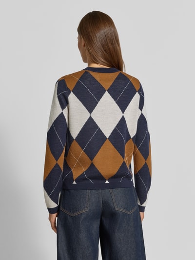 Frauenmodel trägt Regular Fit Strickjacke aus reiner Wolle von GANT, große Rauten in Blau, Braun und Weiß, Ganzkörperansicht Rückansicht. Damen Strickjacke von GANT.