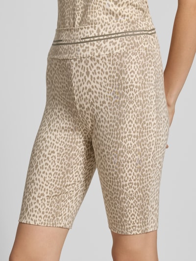 Frauenmodel trägt Radlerhose im Allover-Look Modell 'Roxie' von OH APRIL, Lyocell-Elasthan-Mix, beige-braunes Muster, Ganzkörperansicht Rückansicht.