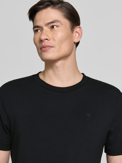 Männermodel trägt T-Shirt mit Rundhalsausschnitt Modell 'Carlonito' von JOOP! Collection, Baumwoll-Mix, schwarz, Nahaufnahme Oberkörper.