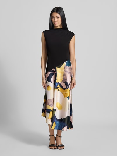 Vrouwenmodel draagt midi-jurk uit zuiver viscose Model 'Aeslyn' van Ted Baker, getailleerde pasvorm, bloemenprint, opstaande kraag, kapmouwen, asymmetrisch design, plooien, ruglengte maat 36: 123 cm, borstwijdte 38 cm, kleuren zwart, geel, roze, detail bloemenmotief, glanzende textuur, geheel van voren gezien.