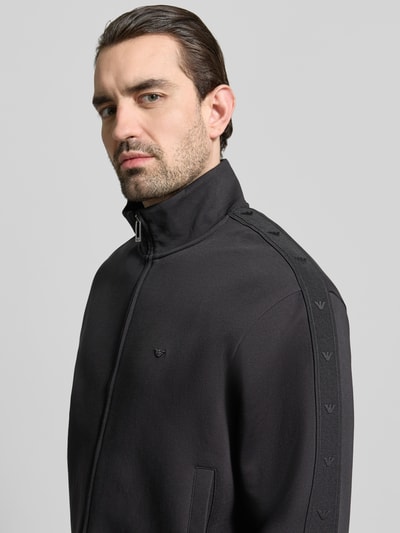 Männermodel trägt Sweatjacke mit Stehkragen und Zweiwege-Reißverschluss von Emporio Armani, Baumwoll-Mix mit Stretch-Anteil, Regular-Fit, Eingrifftaschen, Farbe Schwarz, Nahaufnahme Oberkörper.