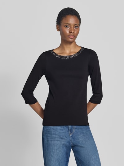 Frauenmodel trägt Regular Fit Shirt aus reiner Baumwolle von Christian Berg Woman, Schwarz, mit Ziersteinen, U-Boot-Ausschnitt, 3/4-Arm, Ganzkörperansicht von vorne.