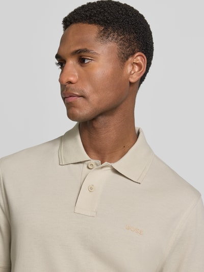 Männermodel trägt Regular Fit Poloshirt aus reiner Baumwolle Modell 'PRIME' von BOSS Orange, efekt: jednolity kolor, krój regular fit, naszywka z logo, kołnierzyk polo, dekolt w serek, krótkie zapięcie na guziki, krótki rękaw, zakończenie rękawów: prążkowane, wykończenie materiału: pika, materiał: bawełna, Nahaufnahme górnej części ciała.