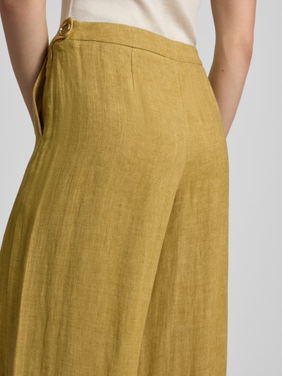 Männermodel trägt Wide Fit Leinenhose mit wpuszczane kieszenie Modell 'LOTTELIA' von Marella, czysty len, zamek błyskawiczny, długość wewnętrzna nogawki 89 cm, szerokość w rozmiarze 36: 37 cm, kolor musztardowy, tkanina o widocznej fakturze, detalaufnahme