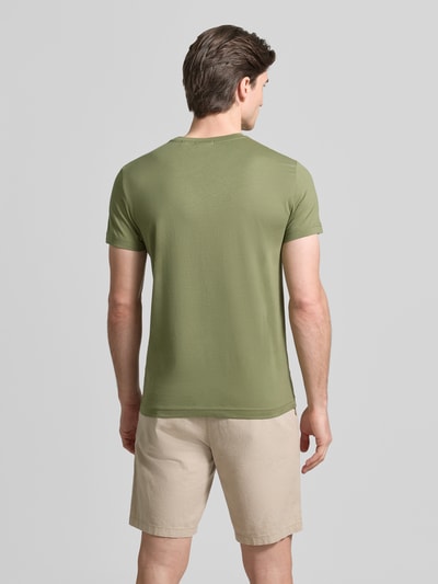 Männermodel trägt T-Shirt mit Label-Detail von Gant in Olivgrün aus reiner Baumwolle, gerader Schnitt, Ganzkörperansicht Rückansicht.