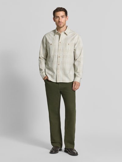 Männermodel trägt Relaxed Fit Jeans mit Eingrifftaschen Modell 'DAMON' von GUESS in Grün, reine Baumwolle, Ganzkörperansicht von vorne.