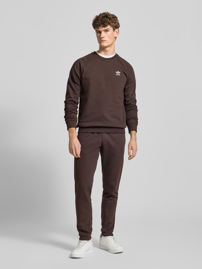 Männermodel trägt Sweatshirt mit Label-Stitching von adidas Originals aus Baumwoll-Elasthan-Mix, lockerer Schnitt, Ganzkörperansicht von vorne.