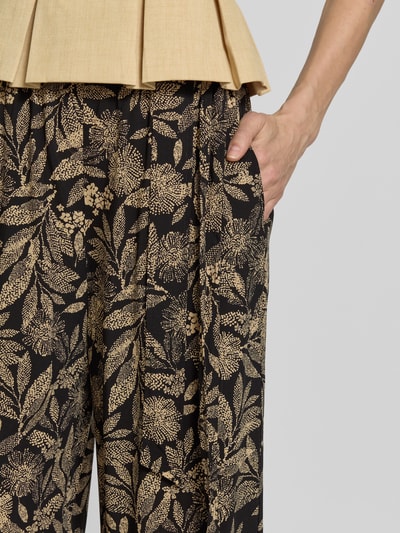 Frauenmodel trägt Culotte aus Viskose mit Bindegürtel von Apricot, florales Muster, französische Eingrifftaschen, Nahaufnahme Oberkörper. Bundweite bei Größe S: 33 cm, Innenbeinlänge bei Größe S: 50 cm, Wide Leg Fit, Reine Viskose, Elastischer Bund.