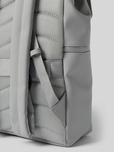 Produktfoto, grauer Rucksack mit Logo-Detail Modell 'SPLÄSH 2.0' von GASTON LUGA, strukturierte Textil- und glatte Kunstlederflächen, Nahaufnahme, Hauptfach mit Überschlag, verstellbare Schulterriemen, Maße 38x40x12 cm, neutrale Hintergrundfarbe