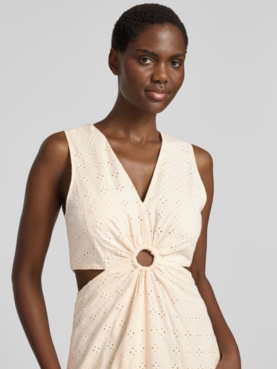 Frauenmodel trägt Midikleid mit floralem Loch-Stitching von MANGO aus reiner Baumwolle in Creme, taillierte Passform mit Cut-Outs, Nahaufnahme Oberkörper.
