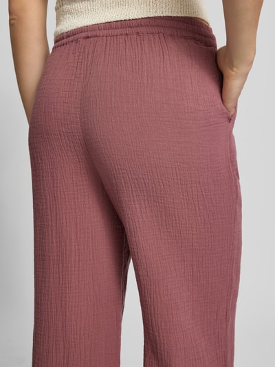 Frauenmodel trägt Relaxed Fit Weite Hose aus Bio-Baumwolle Modell 'THYRA' von Only, Optik: Unifarben, Crêpe-Struktur, seitliche Eingrifftaschen, Bundabschluss elastisch, Nahaufnahme Rückansicht.