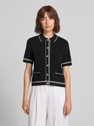 Frauenmodel trägt Cardigan aus Viskose-Mix mit 1/2-Arm von Jake*s Collection, schwarz mit Kontraststreifen, Knopfleiste, Polokragen, Ganzkörperansicht von vorne.