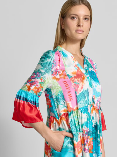 Frauenmodel trägt Relaxed Fit Minikleid aus reiner Viskose Modell 'Breeze' von miss goodlife mit floraler Allover-Print, Halbarm, V-Ausschnitt, Knopfleiste, Falten-Optik in bunten Farben, Nahaufnahme Oberkörper.