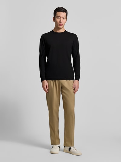 Männermodel trägt Regular Fit Langarmshirt aus reiner Baumwolle von Tom Tailor, unifarben, Rundhals, Jersey, Ganzkörperansicht von vorne.