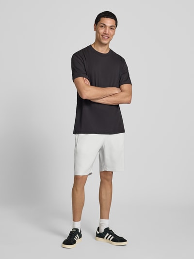 Männermodel trägt Shorts mit Logo Modell 'Troy' von Pegador in Weiß, Material-Mix mit Stretch-Anteil, Regular-Fit, Ganzkörperansicht von vorne.