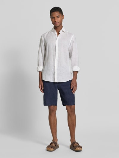 Männermodel trägt Straight Fit Leinenshorts mit Gesäßtaschen von Gant in Dunkelblau, reine Leinen, elastischer Bund, Ganzkörperansicht von vorne.