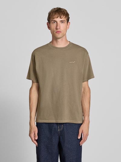 Männermodel trägt Relaxed Fit T-Shirt aus reiner Baumwolle Modell 'VINTAGE TEE' von Levi's®, beige, glatte Textur, Herren T-Shirt, Ganzkörperansicht von vorne.