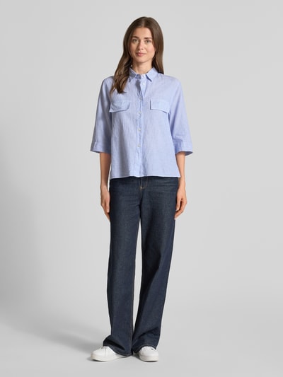 Frauenmodel trägt Bluse aus Leinen-Mix mit Brusttaschen Modell 'BEA' von 0039 Italy, hellblau, Loose-Fit, Ganzkörperansicht von vorne. Rückenlänge 57 cm, Ärmellänge 37 cm, Hemdblusenkragen, Knopfleiste, 3/4-Arm, Leinen-Baumwoll-Anteil.