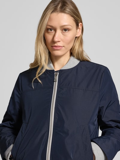 Vrouwenmodel draagt donkerblauwe bomberjack met opstaande kraag, tweewegritssluiting en steekzakken, regular fit, Bomberjacke mit Zweiwege-Reißverschluss van Amber & June, ruglengte maat 36: 59 cm, schouderbreedte: 37 cm, borstwijdte: 50 cm, mouwlengte: 66 cm, Nahaufnahme bovenlichaam.