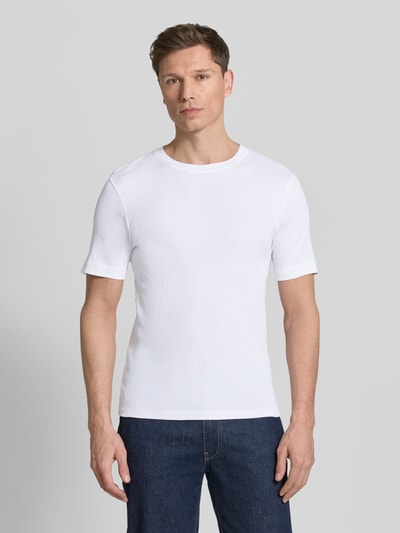 Männermodel trägt weißes Herren T-Shirt mit Rundhalsausschnitt Modell 'ENIL' von Drykorn aus reiner Baumwolle, Slim-Fit, Ganzkörperansicht von vorne. Rückenlänge bei Größe M: 66 cm.