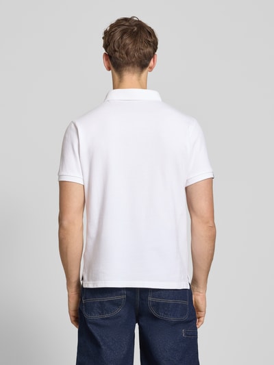 Męski model nosi Regular Fit Poloshirt mit Logo-Stitching von Superdry z bawełny, kołnierzyk polo, krótki rękaw, długość tyłu w rozmiarze M: 67 cm, widok całej sylwetki od tyłu.