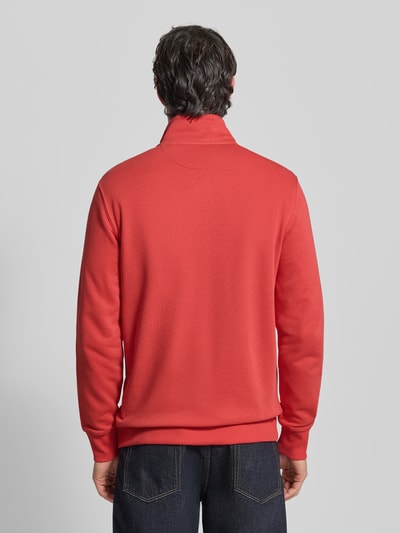 Męski model ma na sobie Regular Fit Sweatjacke mit Stehkragen Modell 'Gield' od Gant w kolorze czerwonym, bawełniany miks, dzielona kieszeń kangurka, logo, elastyczne wykończenia, długość tyłu 69 cm, długość rękawa 64 cm, widok całej sylwetki od tyłu
