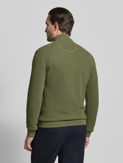 Männermodel trägt Cardigan mit Zweiwege-Reißverschluss und Label-Stitching von Gant in Oliv, Slim Fit, reine Baumwolle, Stehkragen, Rückenlänge 70 cm, Ärmellänge 64 cm, Ganzkörperansicht Rückansicht.