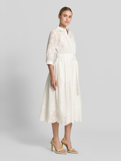 Frauenmodel trägt Hemdblusenkleid aus Lochspitze mit Knopfleiste von Milano Italy, Reine Baumwolle, Taillierter Schnitt, Midikleid, Bindegürtel, Hemdblusenkragen, Knopfleiste, Rückenlänge 121 cm in Größe 36, Brustweite 41 cm, Ärmellänge 38 cm, cremefarben, Ganzkörperansicht von vorne.
